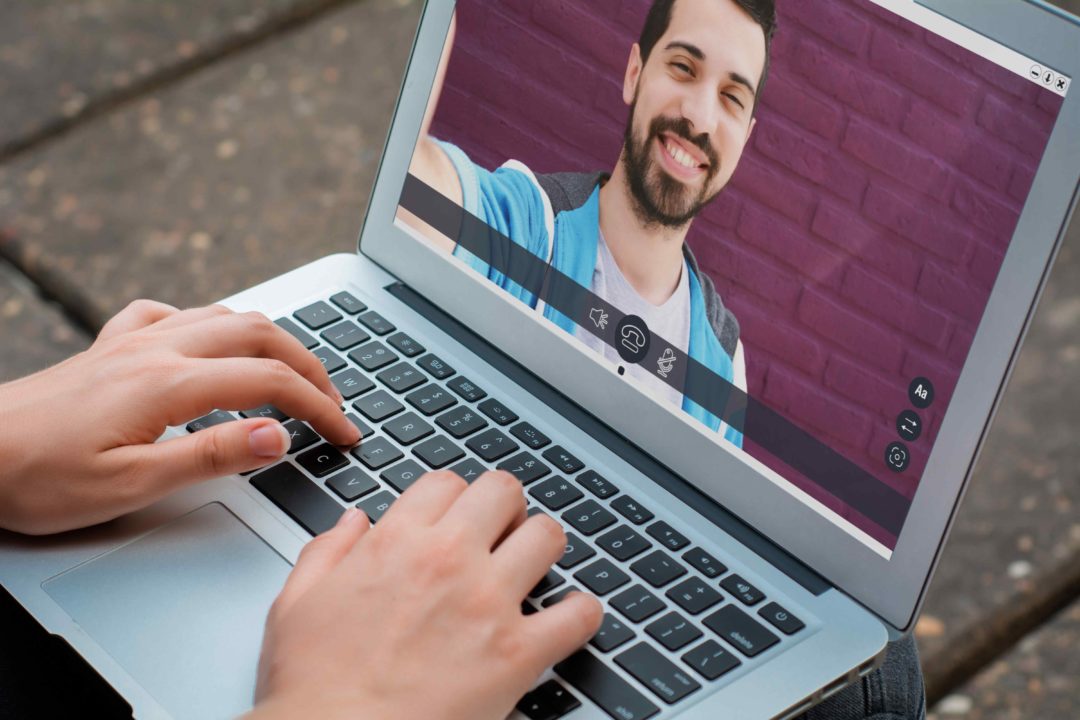 Closeup of woman chatting online by making video call on laptop with her friend. Social media concept. All screen graphics are made up by us