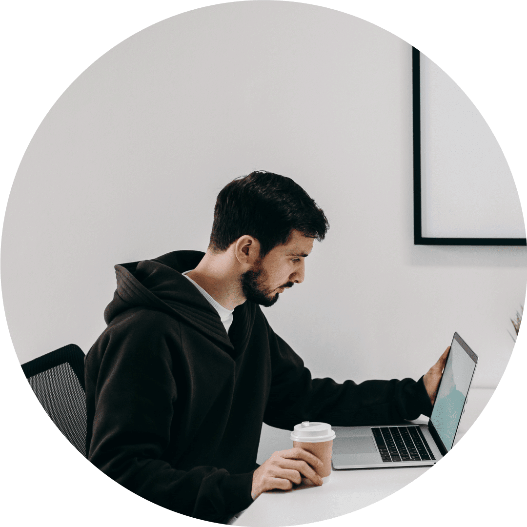 developer working on his laptop while holding a cup of coffee